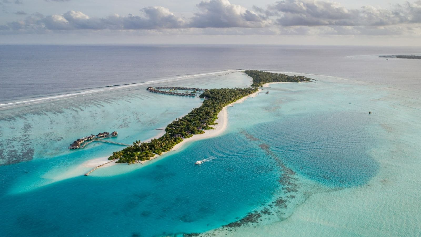 Aerial view of a Maldives island ringed by a turquoise lagoon