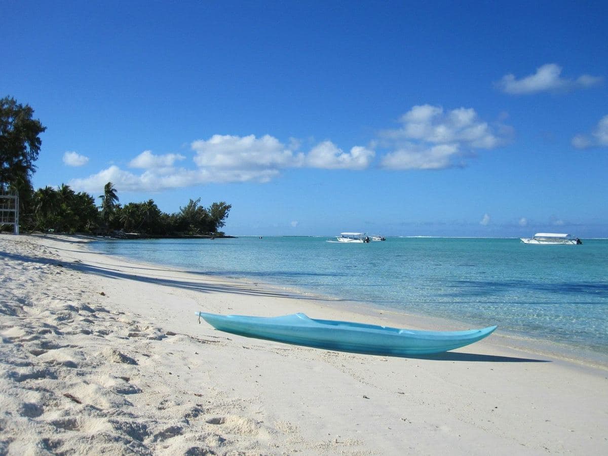 An outrigger kayak on white sand
