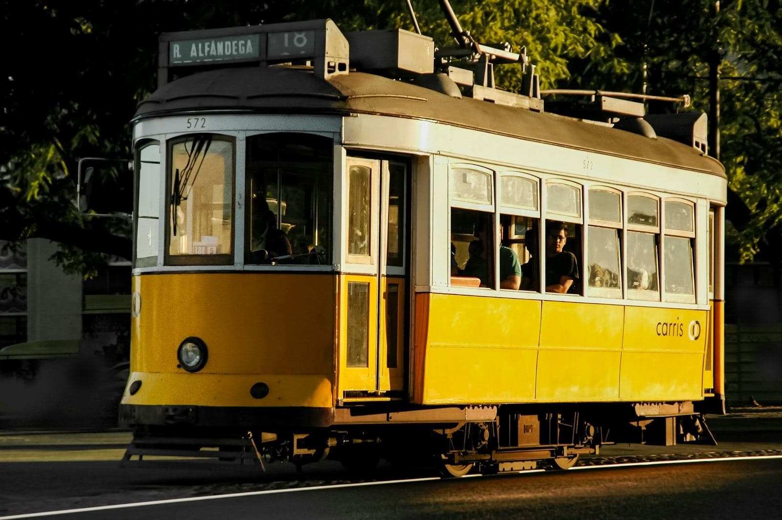 A yellow Lisbon tram in golden evening light