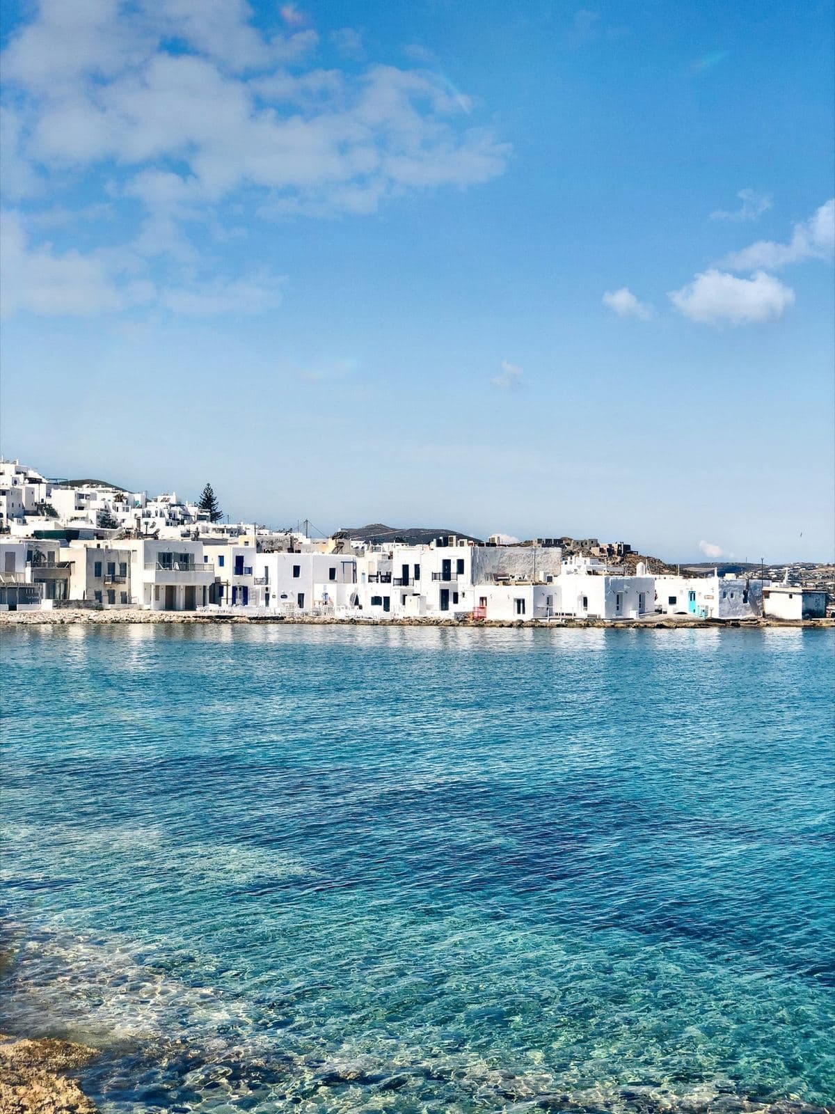 Whitewashed waterfront on Paros above clear blue water