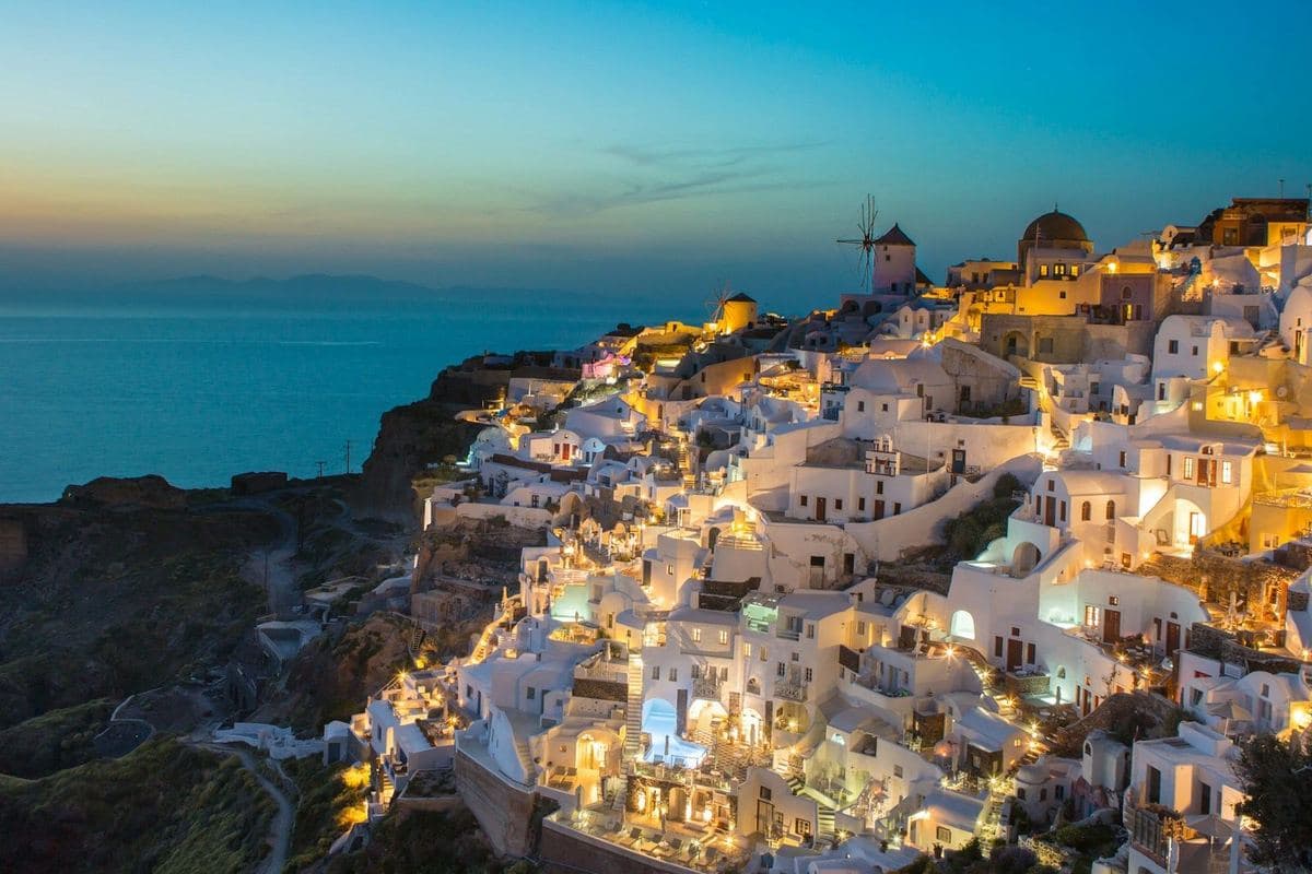 Oia's cliffside lit up at dusk